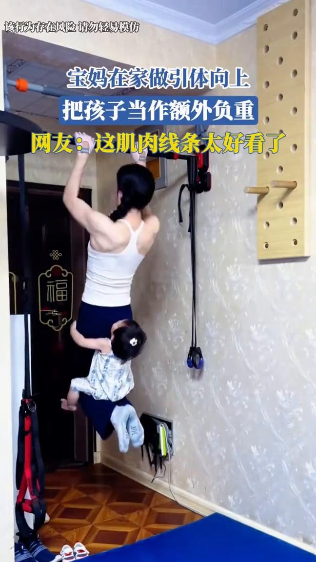 宝妈在家做引体向上，把孩子当作额外负重。
网友：这肌肉线条太好看了。