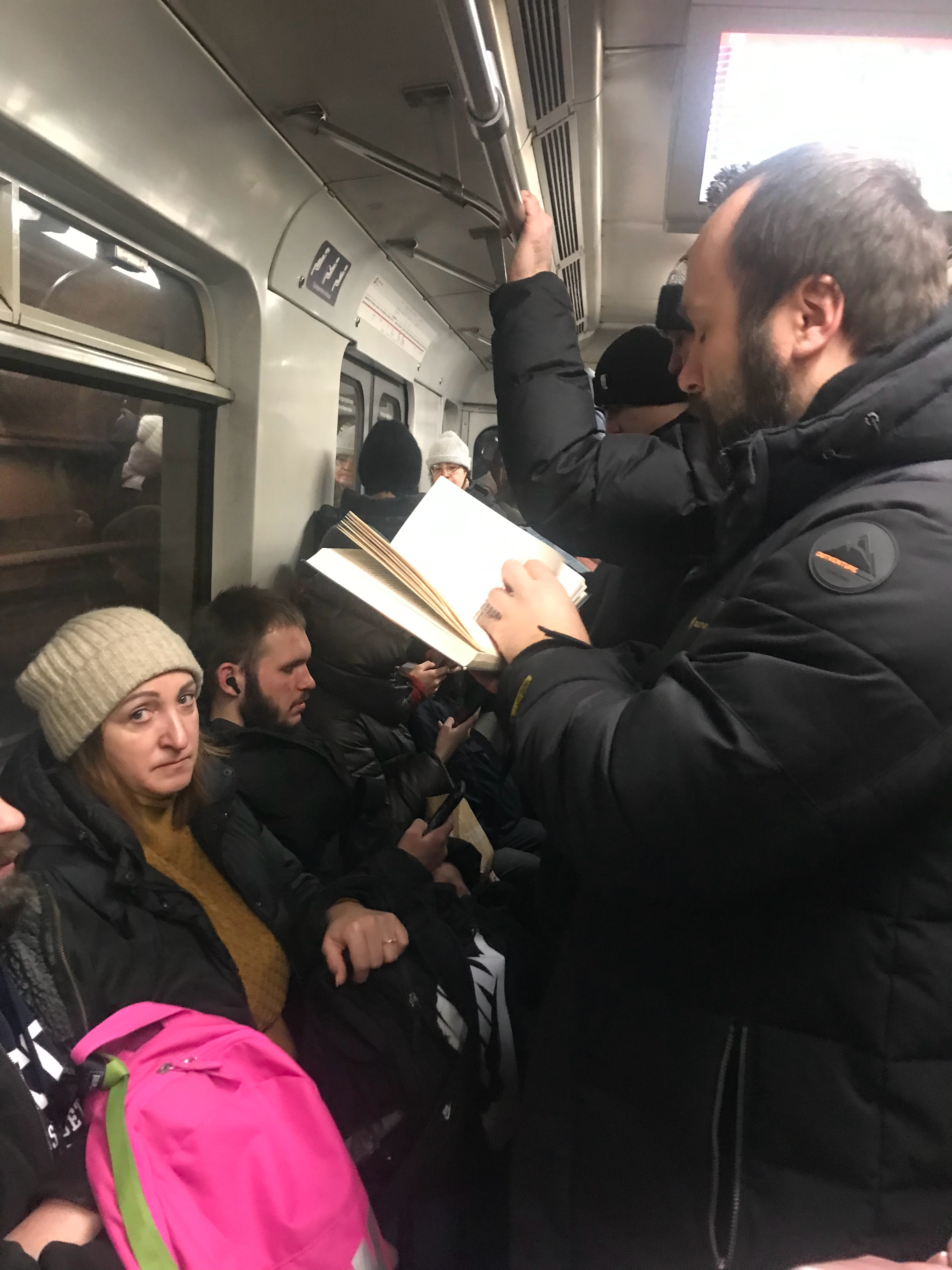 基辅地铁上，三个人站着看书 乌克兰·基辅