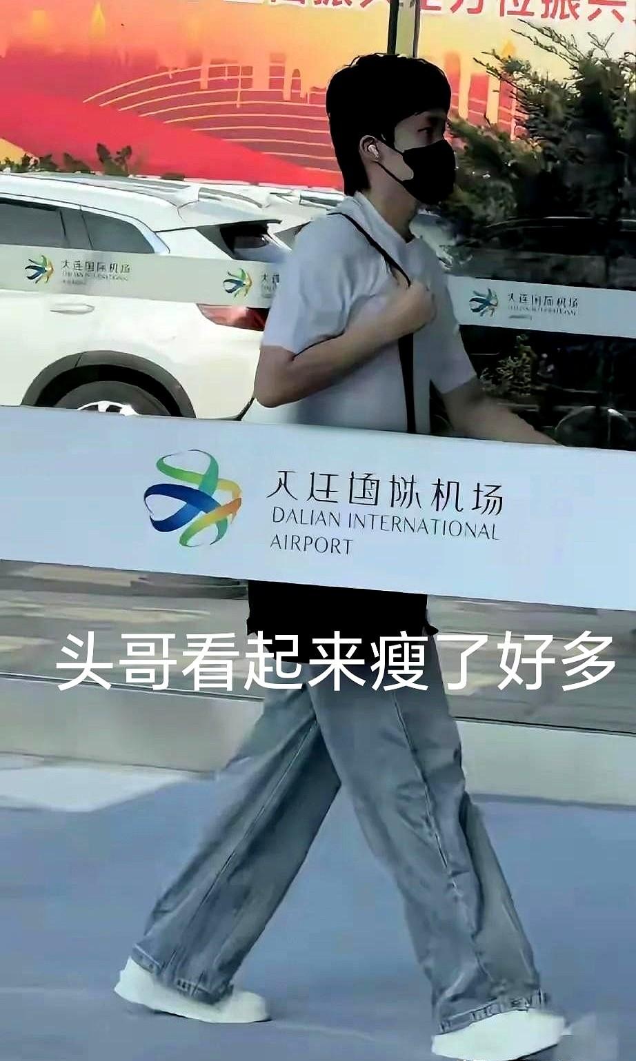 头哥今天一大早就从大连出发了，奔赴下一站了！
他穿着单薄的白T恤和牛仔裤匆匆赶路