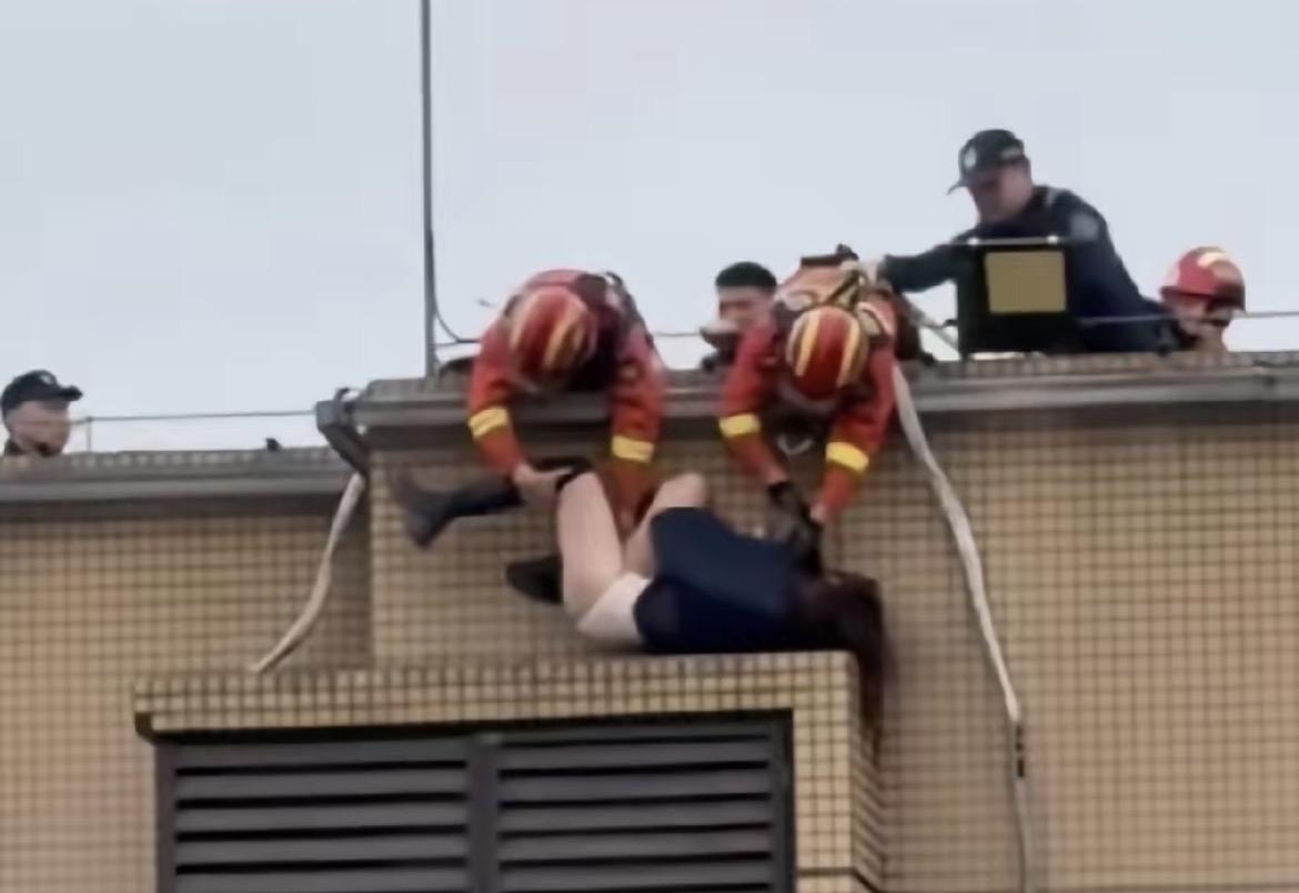 这不是演戏，是现实里让人揪心的一幕。
一名女子站在高处想要轻生，消防员拼尽全力把