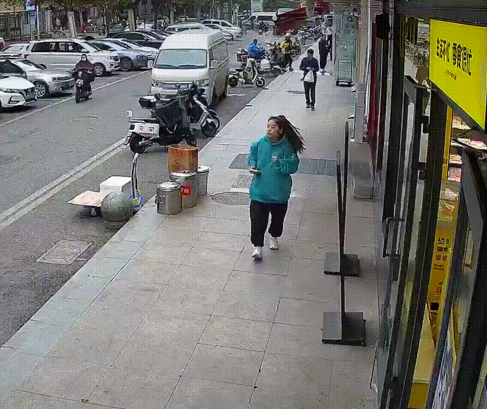 一位美女经过路边一家零食店，零食店门口有两个立着的招牌，第一个招牌先倒地拦住了美