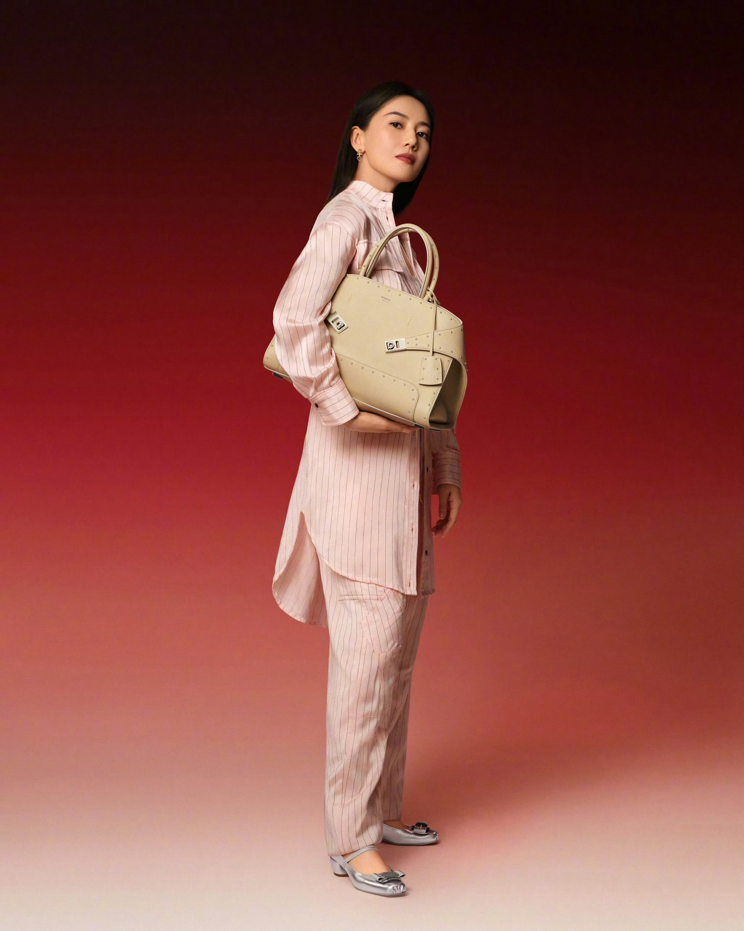 粉白条纹套装自带温柔松弛感，利落剪裁又藏着通勤的干练。黑色镂空手袋是点睛之笔，在