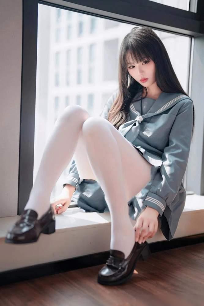 阳光洒进来的瞬间，少女在窗边静坐，黑白校服与白色丝袜相映成趣，静谧而美好。上联：