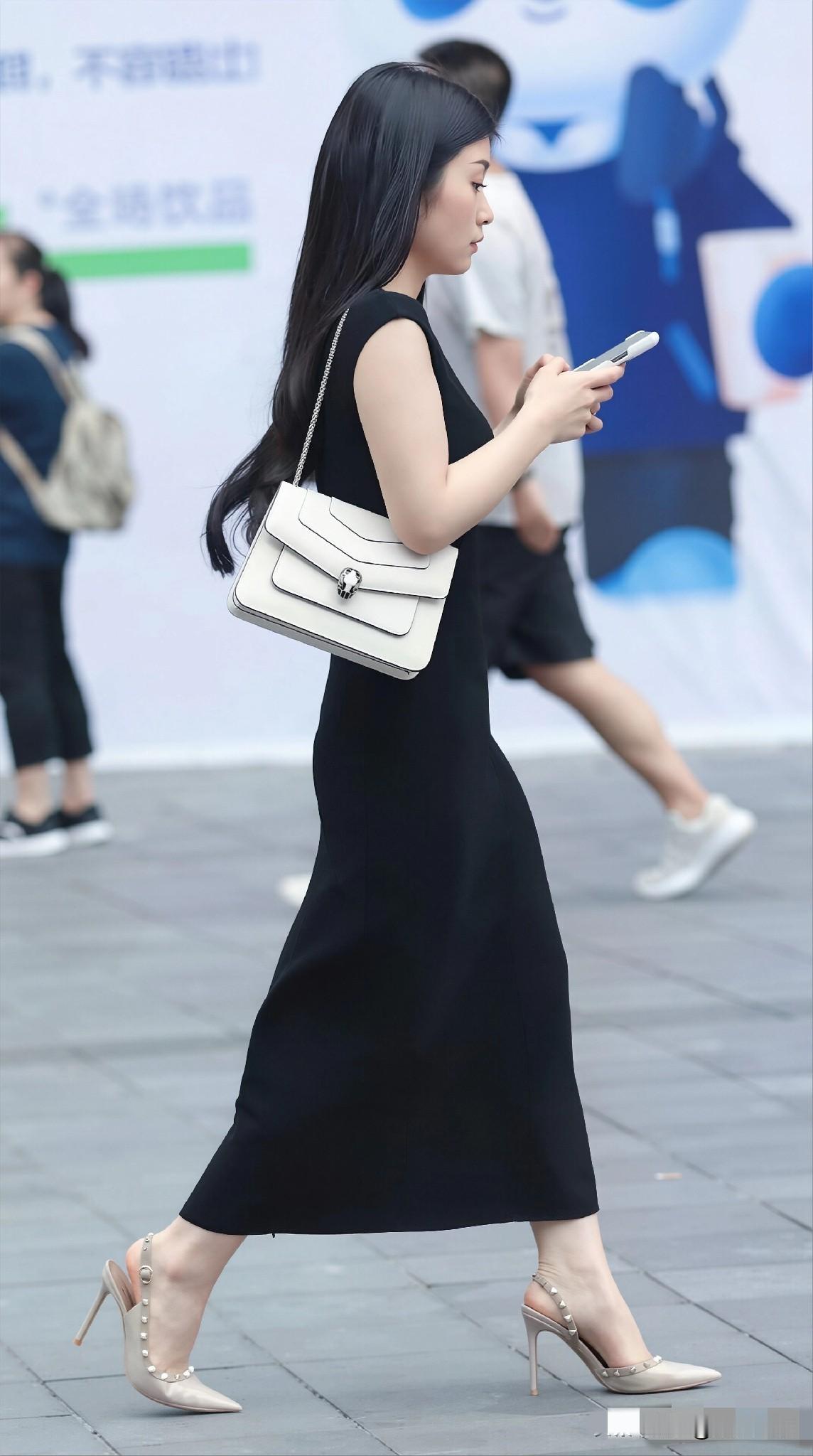 黑色无袖针织连衣裙+浅米色尖头细高跟凉鞋，简约又不失精致
行走在城市街头，每一步