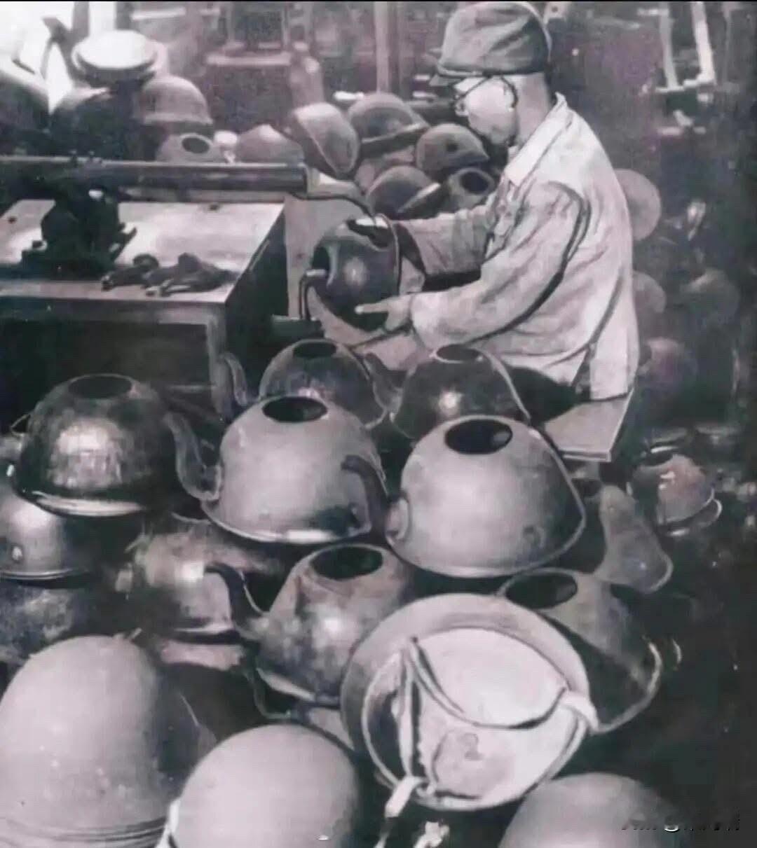 这张历史照片记录了二战后日本的一种特殊资源再利用现象：工匠正将废弃的军用头盔改装