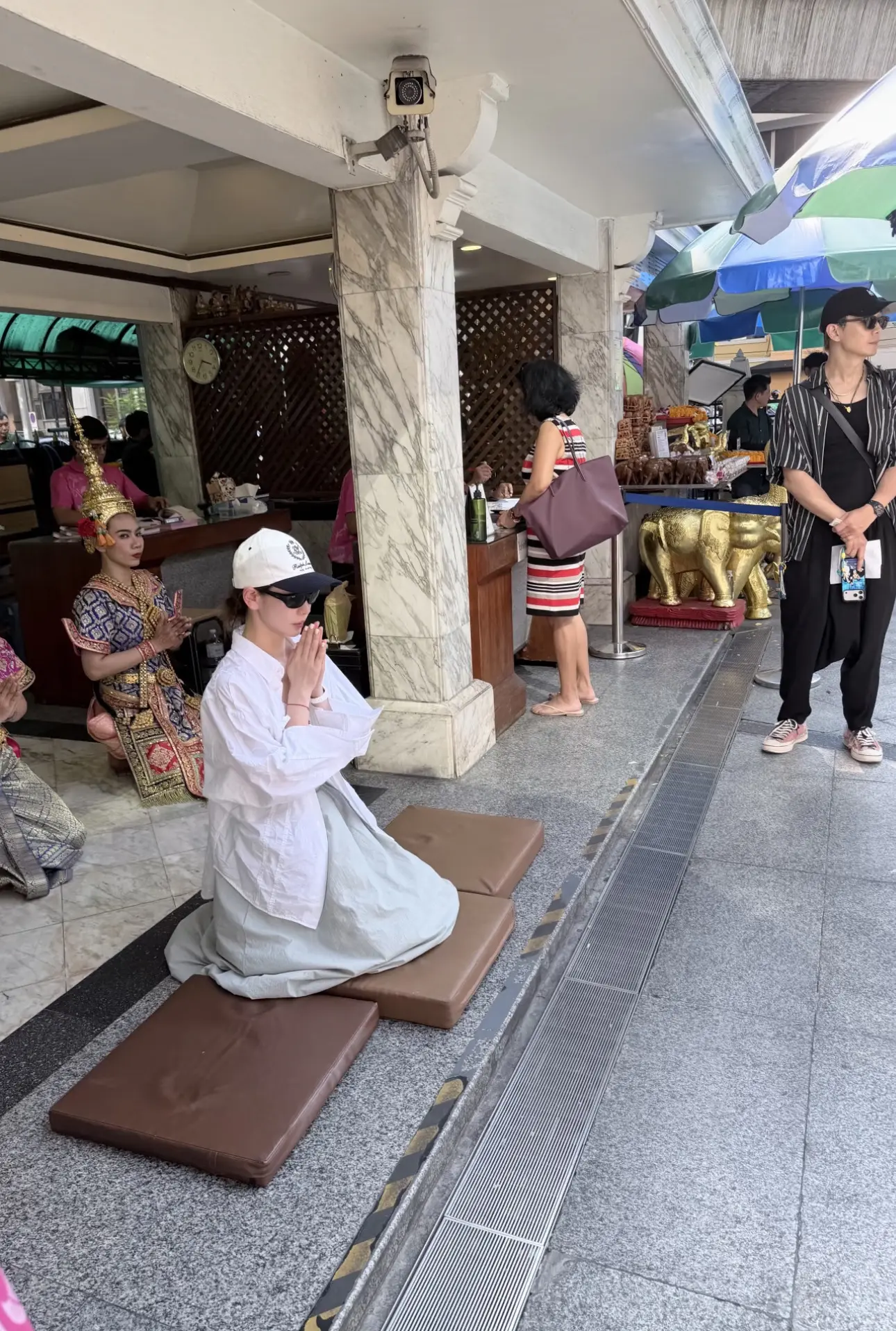 戚薇和李承铉在马来西亚被偶遇，她戴着墨镜和帽子跪拜却引发争议