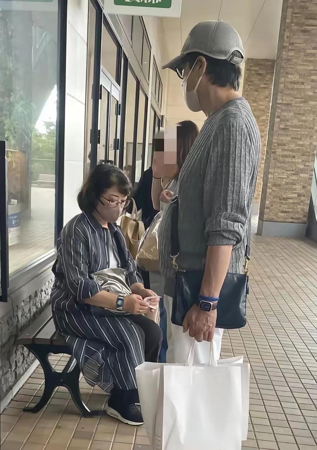 一对影坛爱情传奇！将要步入金婚了。逛完街在外等位吃饭，山口百惠坐着低头在看拿到的