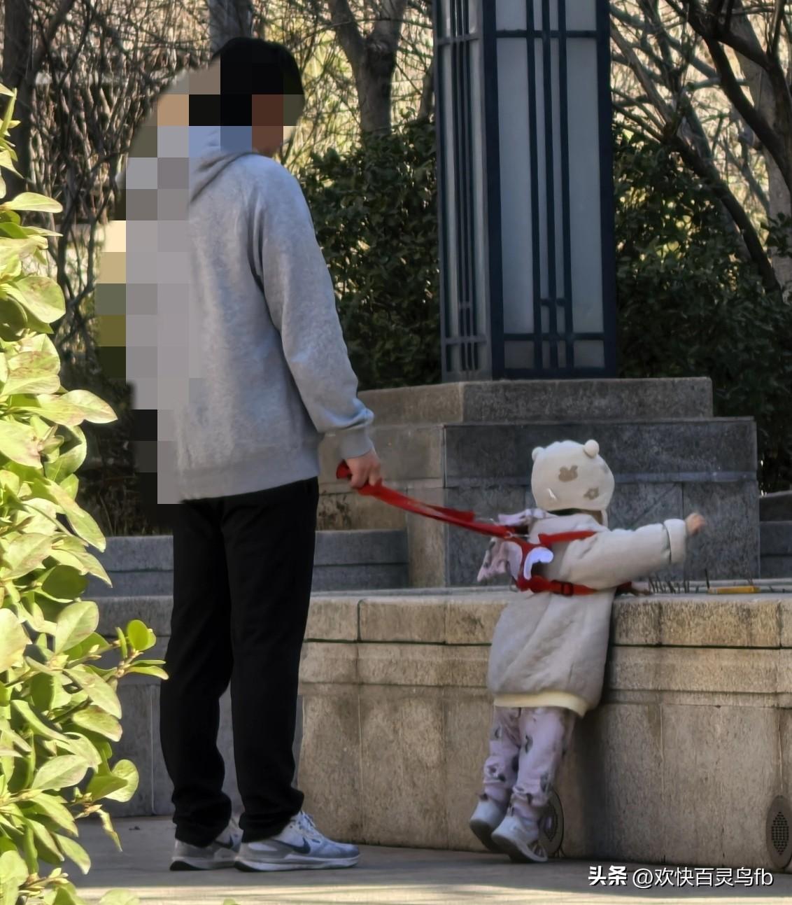 这是亲生的吗？为什么要拴着？
远看像牵着一只小狗，
走近一看，牵的是一个小孩子。