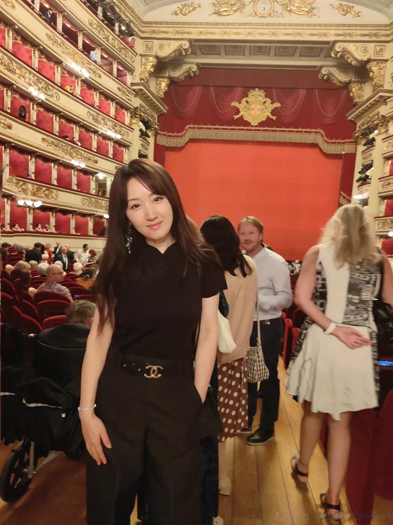 杨钰莹打卡米兰斯卡拉歌剧院，穿黑色体恤搭配阔腿喇叭裤，看起来十分减龄，一头乌黑茂