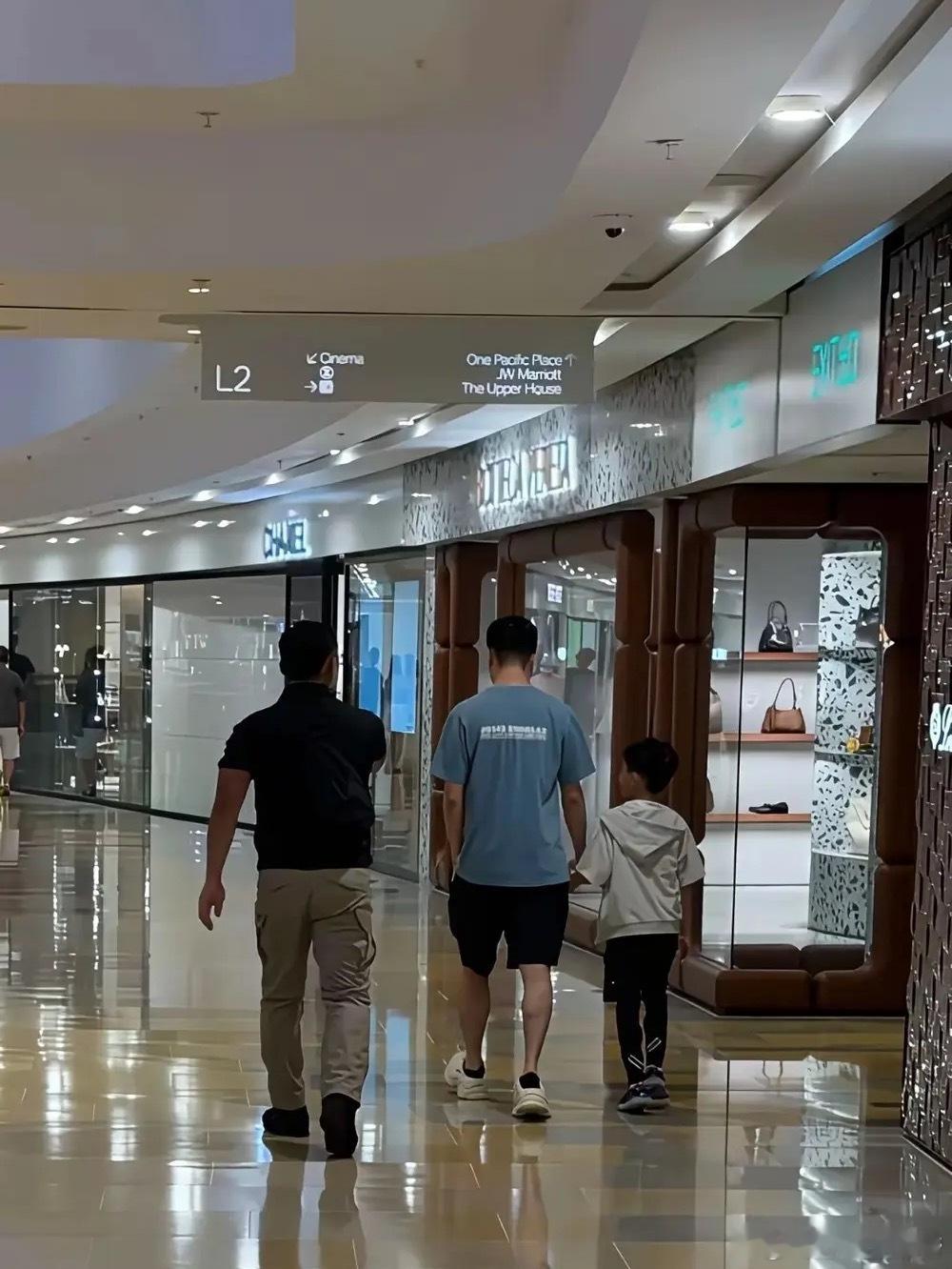 网友在香港太古广场偶遇31岁的何猷君，他正带着7岁的大儿子何广燊出门逛街采购，身