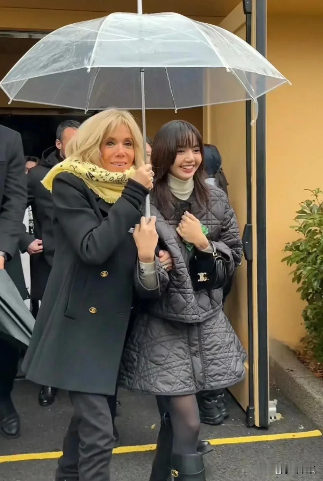 法国第一夫人亲自帮Lisa撑伞，两人偎依在一起，就像一对母女。Lisa看来是人见