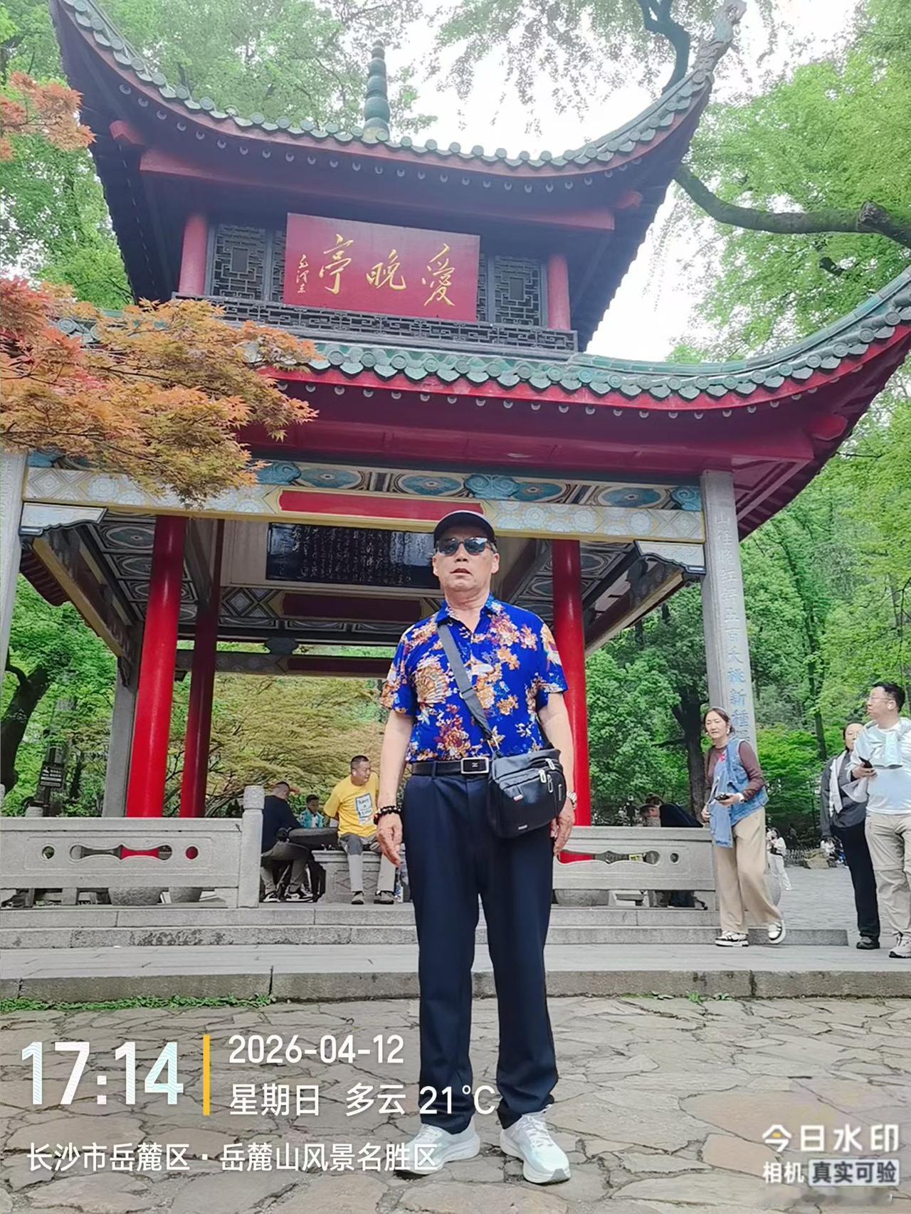 在风景名胜区，一个穿花衬衫的人拍照。