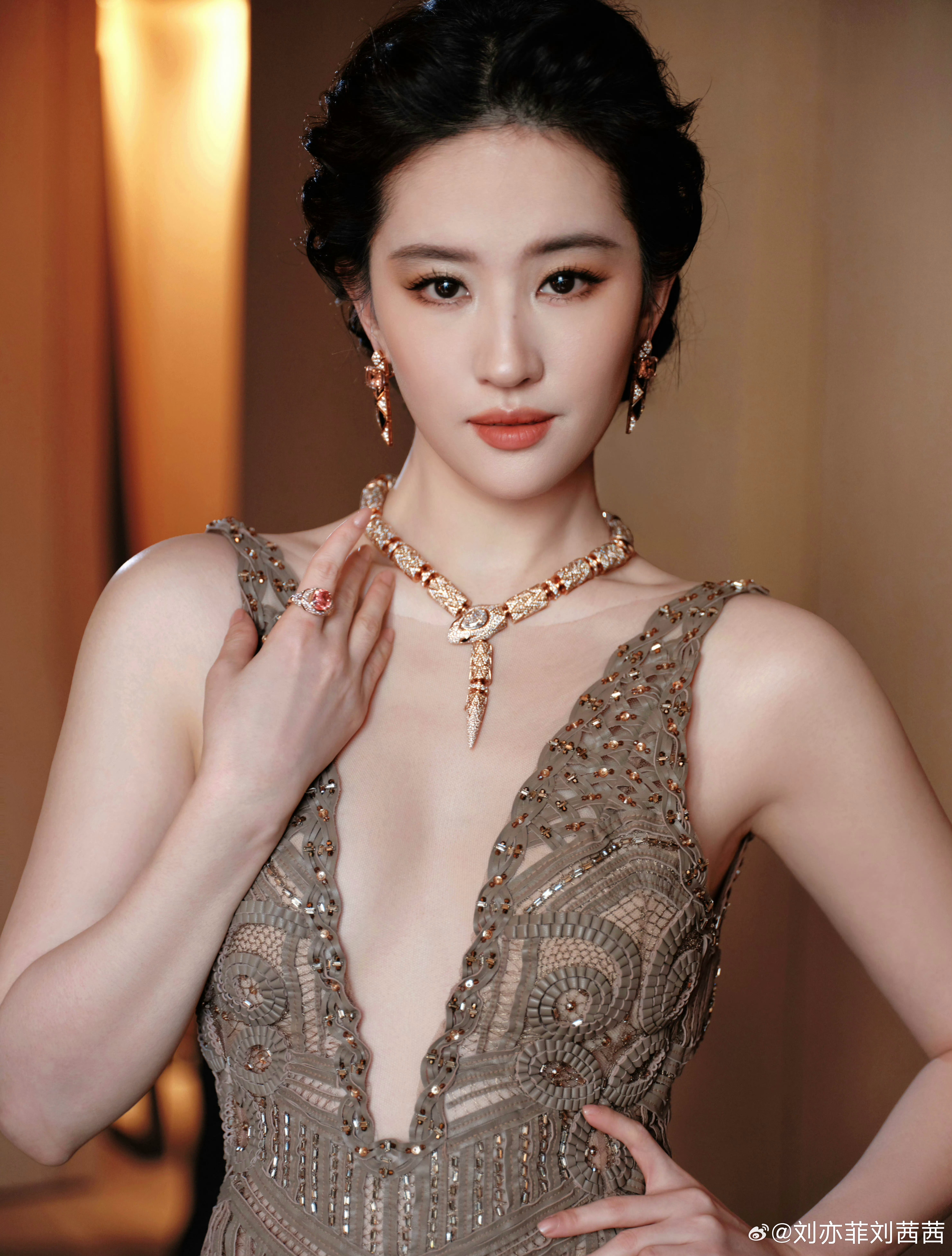 刘亦菲身着咖色深V镂空礼裙，编织纹理与满钻点缀交织出高级质感，深V剪裁勾勒肩颈线