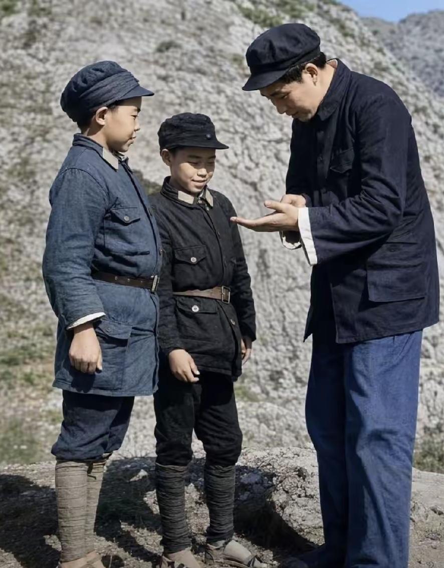 1939年伟人在延安与两位小八路刘长贵、安定宝交谈。他弯腰贴近，用手指在掌心比划