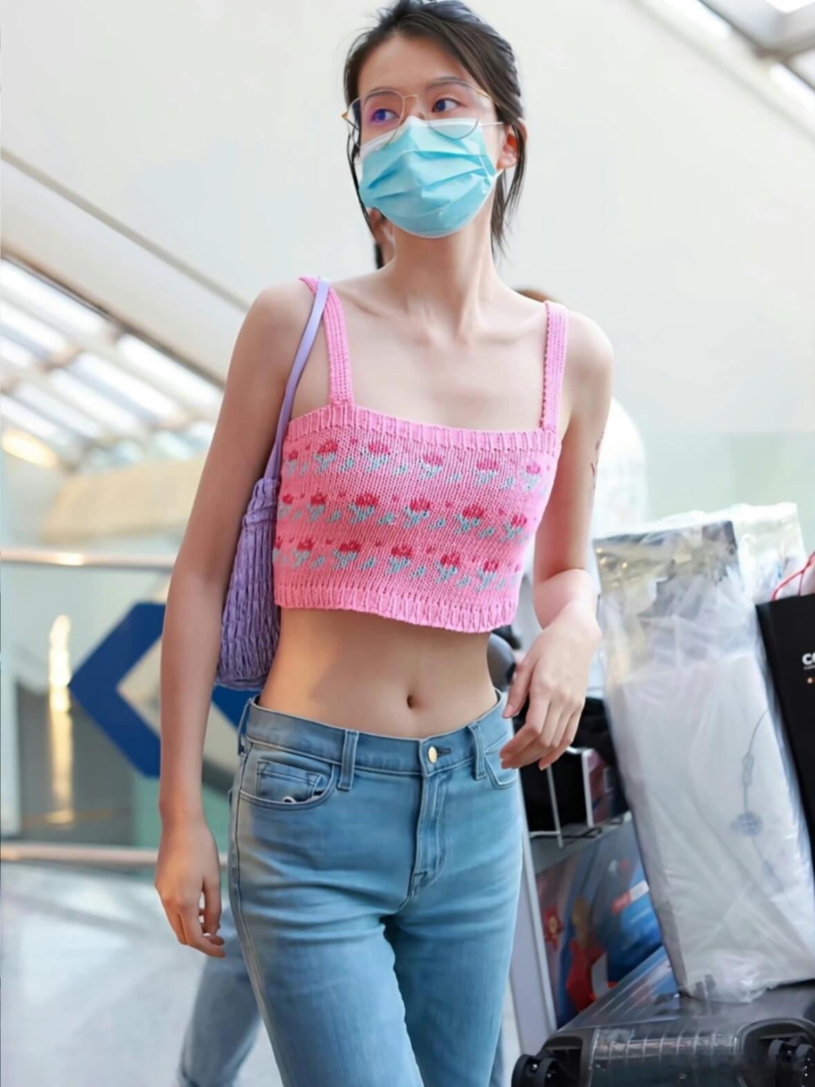 乔欣机场粉蓝撞色穿搭，露脐吊带配喇叭牛仔裤清爽吸睛。 ​​​