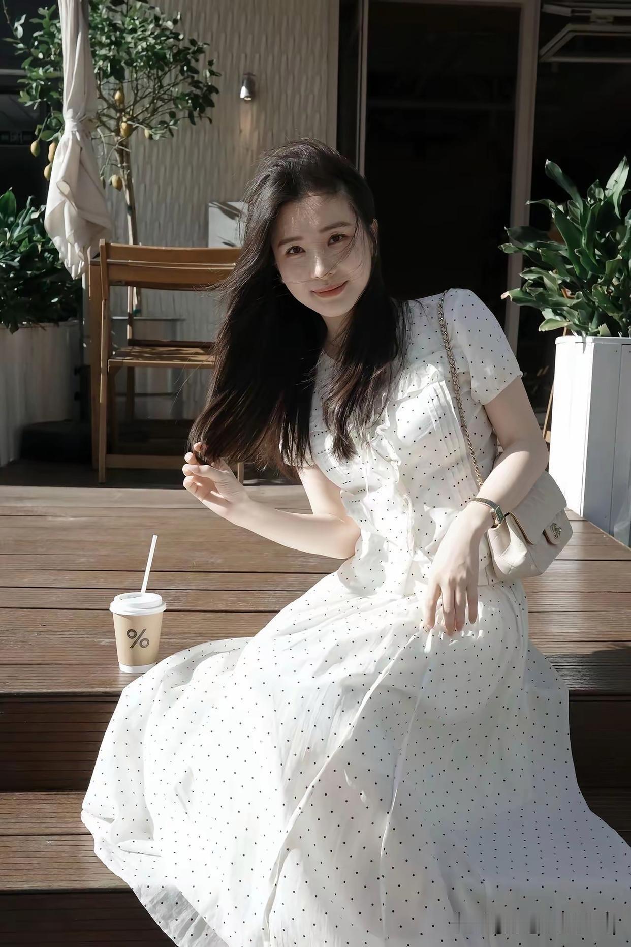 女孩子怎么穿搭既时尚又好看? 阳光下的甜美少女，轻纱裙摆随风飘逸，手捧咖啡，享受
