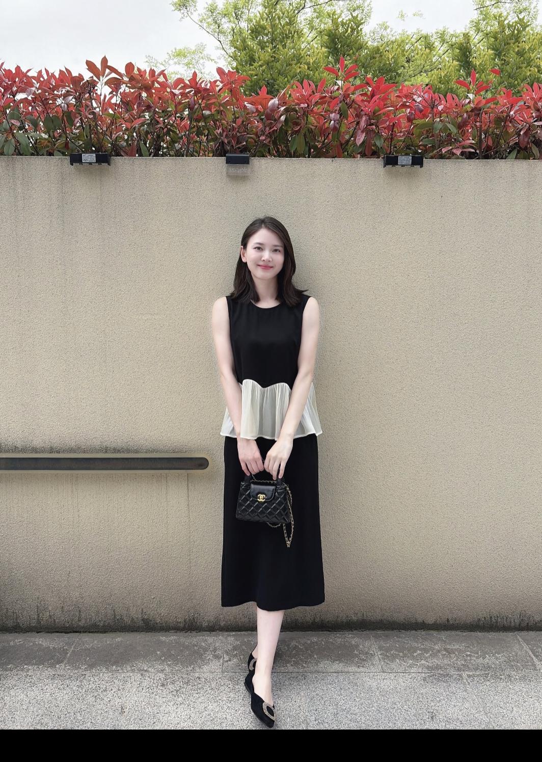 在街角不经意撞见的瞬间，才懂什么叫“自带氛围感”。她一身简约黑裙，被阳光衬得温柔