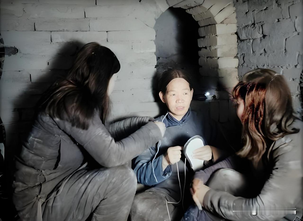 这张摄于1944年冀中地道的照片，定格了三位妇女在地道里低头纳鞋的场景，手中的锥