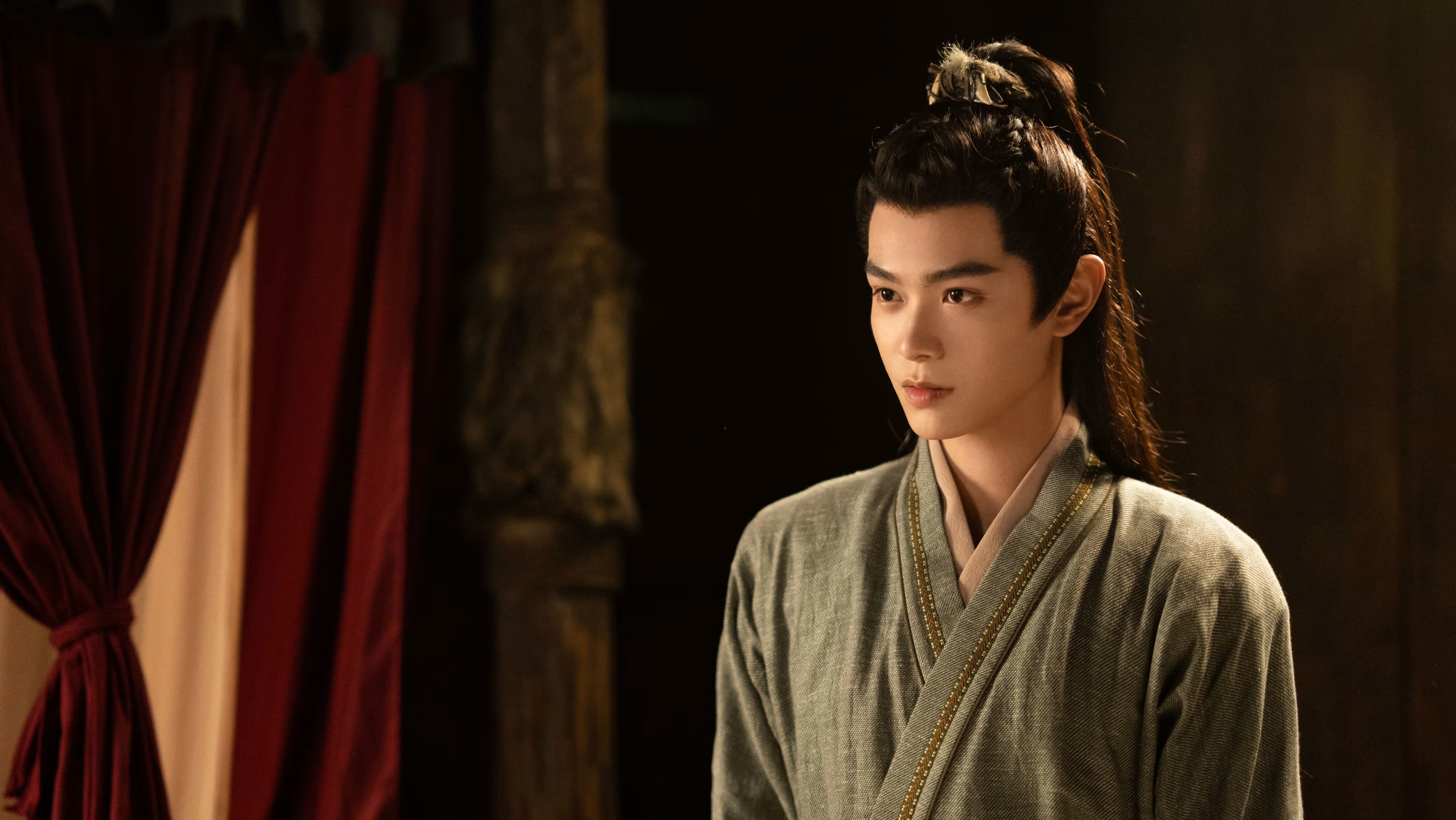 |   卫韫着素衣立暗处，眉峰微敛藏隐忍，眸底情绪似有千言未说。