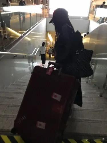 中午，在西流湖地铁站C出口出站，看到一个女孩子站在楼梯口，她拎着皮箱准备下楼梯，