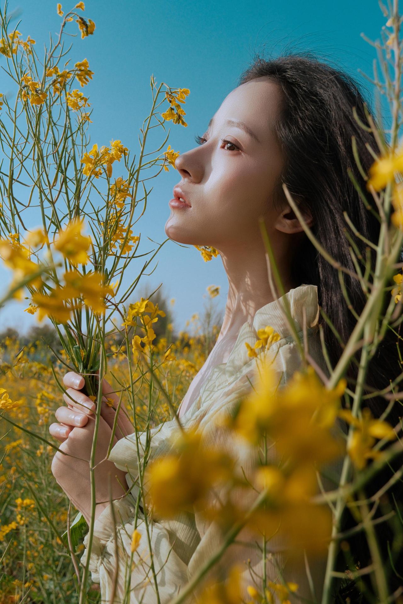 作品采用了逆光拍摄，将人物置于夕阳斜射的光线中，发丝边缘被勾勒出一层柔和的金边，