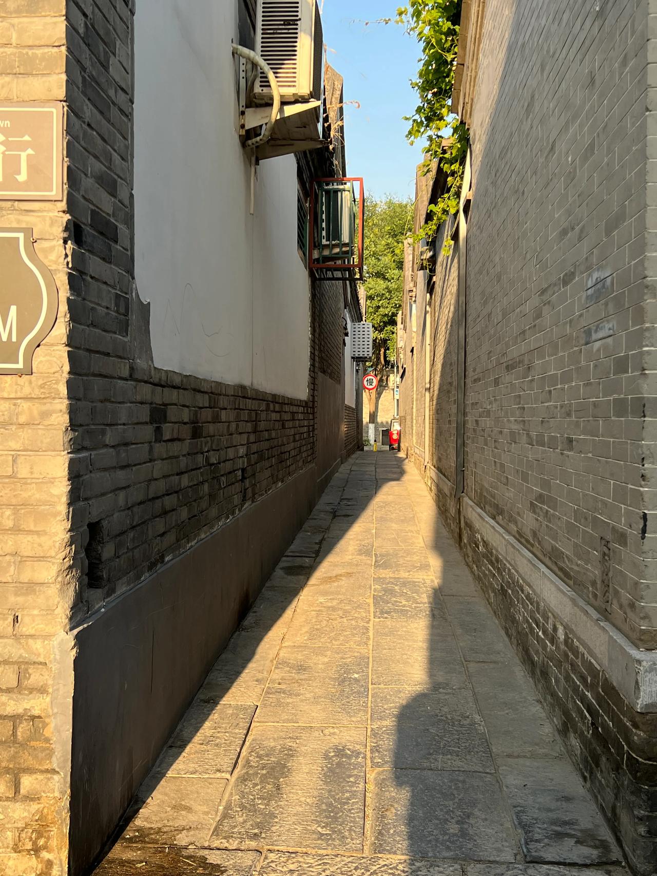 本来是一条近一里多长的胡同，临到尽头突然变窄了，只能通过一辆摩托车，双向瞭望才能