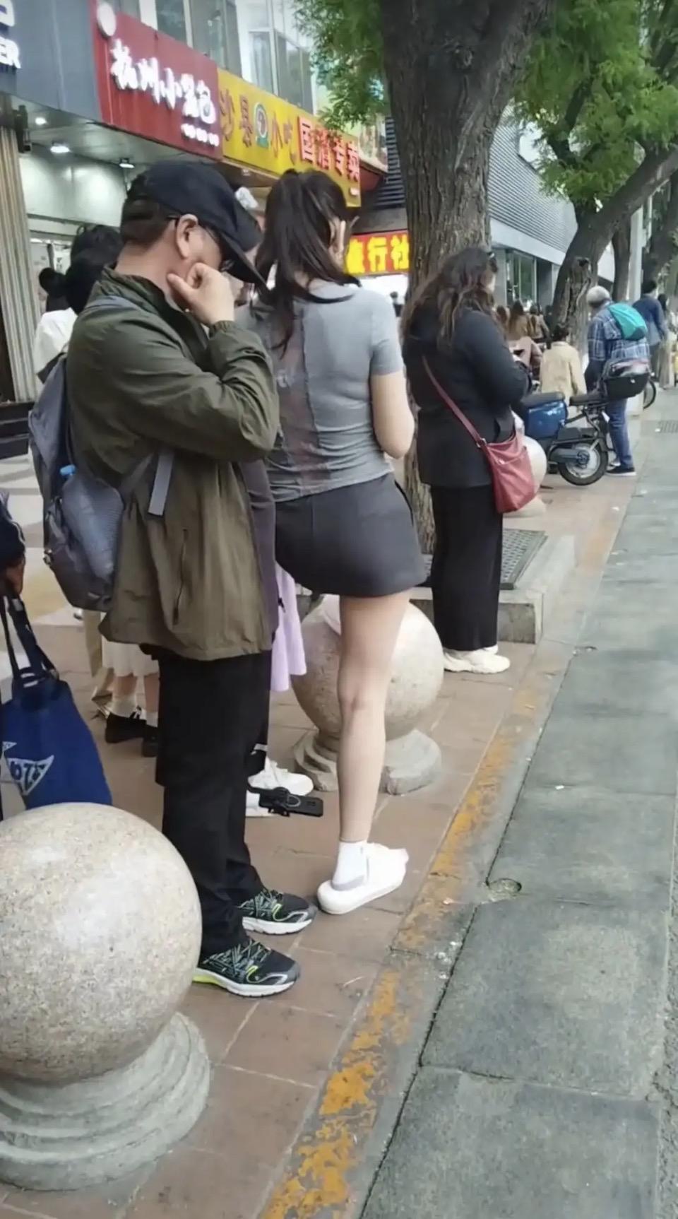 放学的铃声还没响，校门口已经排起了长队。我攥着保温杯，站在石球旁，和其他家长一起