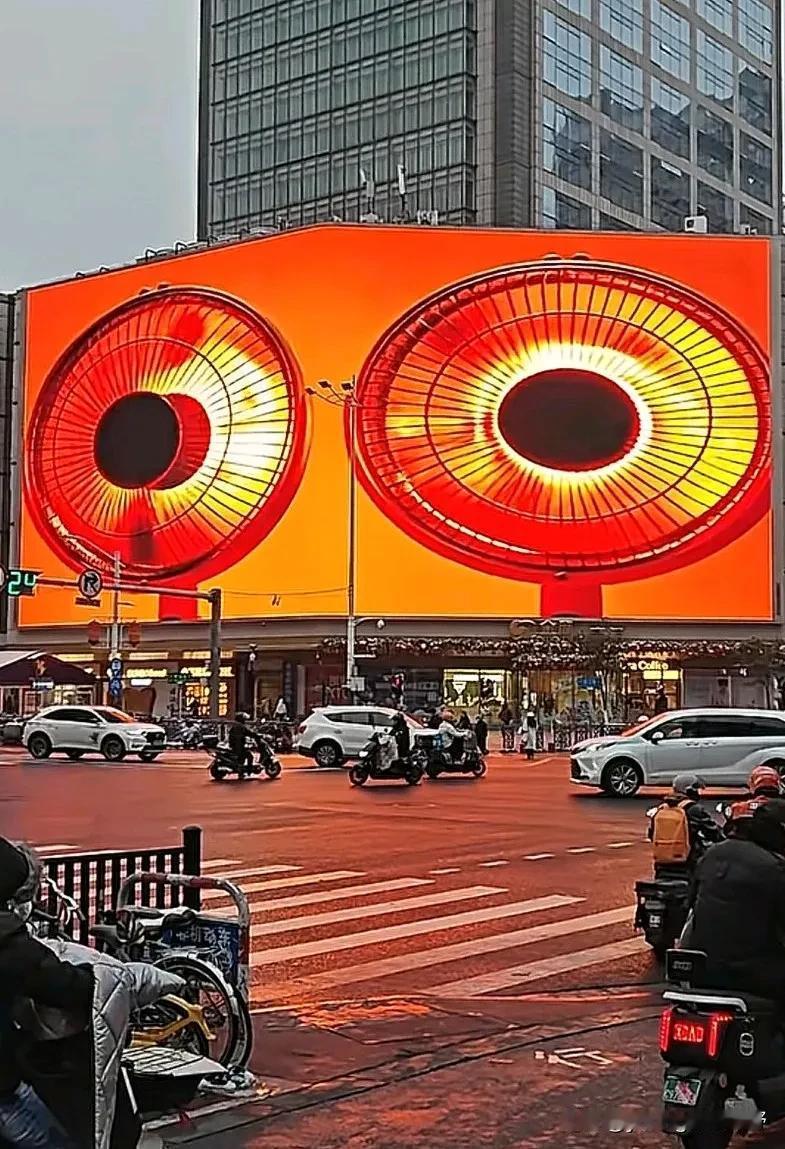 南京街头，商场在外部的大屏幕上直接放上多个小太阳电暖器的影像，连门口的道路颜色都