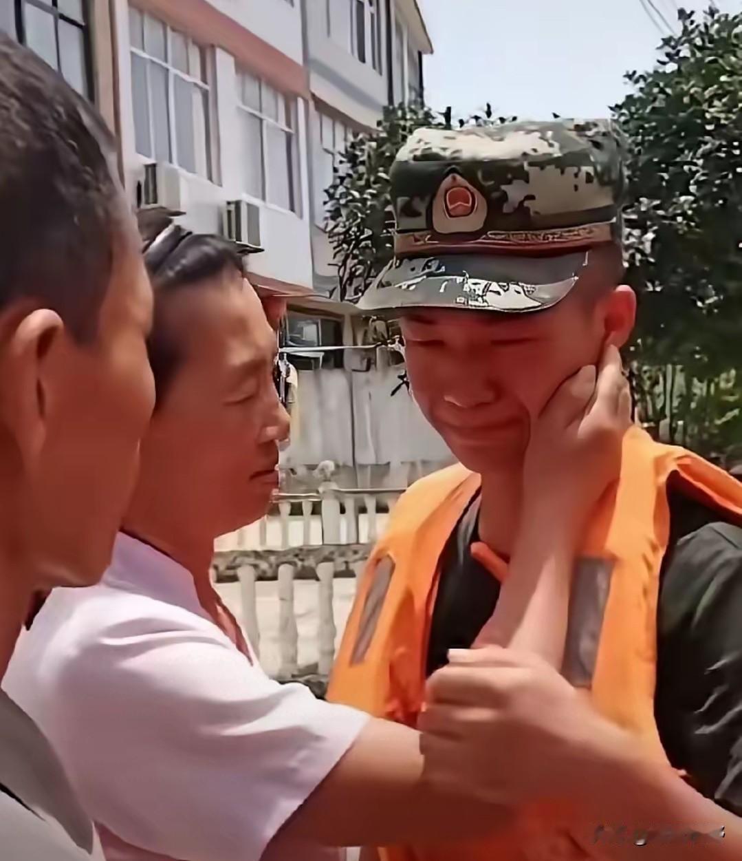 这位兵哥哥跟着部队驰援自己的家乡抗洪，在转移群众的路上，撞见了赶来的父母。
他紧