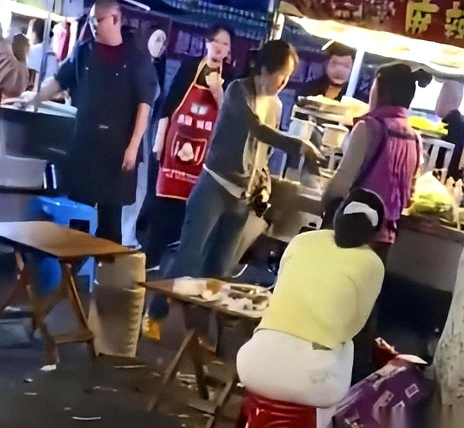 重庆开州区实验中学门口，一个摆摊的阿姨膝盖一软，当众给一个女人跪下了。
围观的人