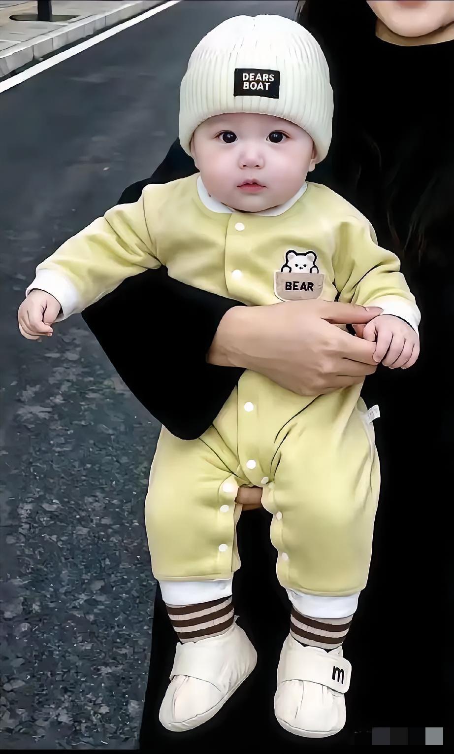 可怜的孩子呀！皮肤嫩嫩的，长得白白胖胖，一双眼睛乌黑油亮，穿着软软的小衣服，戴着