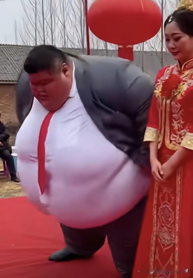 红毡上的婚礼

红毡铺陈于地，红灯笼在料峭的春风中摇曳着暖光。新郎身形显得臃肿，