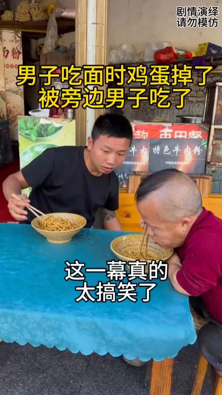 男子吃面时鸡蛋掉了，被旁边男子吃了，这一幕真的太搞笑了。
男子吃面时鸡蛋掉桌上了