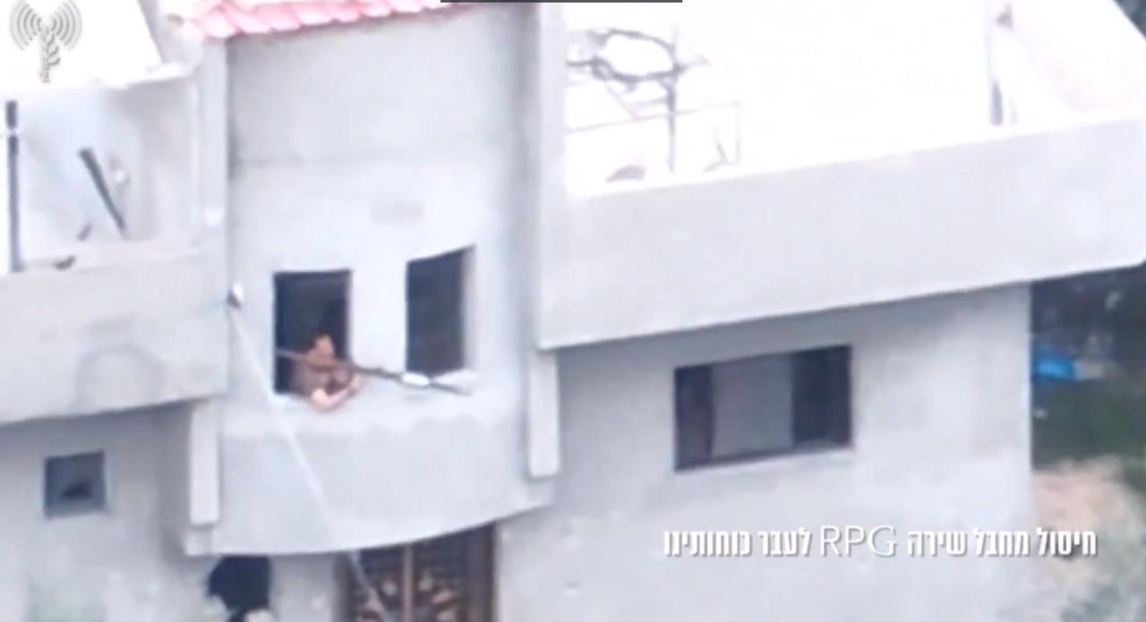 一名哈马斯武装人员正藏身于一栋民宅内，向以色列军队发射一枚火箭推进榴弹（RPG）