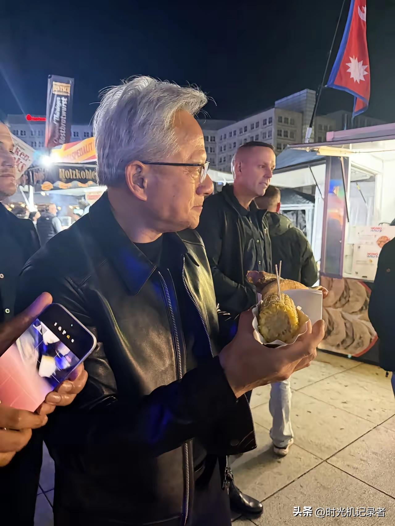 黄仁勋在柏林夜市闲逛，真的太惹人注目了，黑色皮衣依然不变，玉米和肉饼吃的很美味。