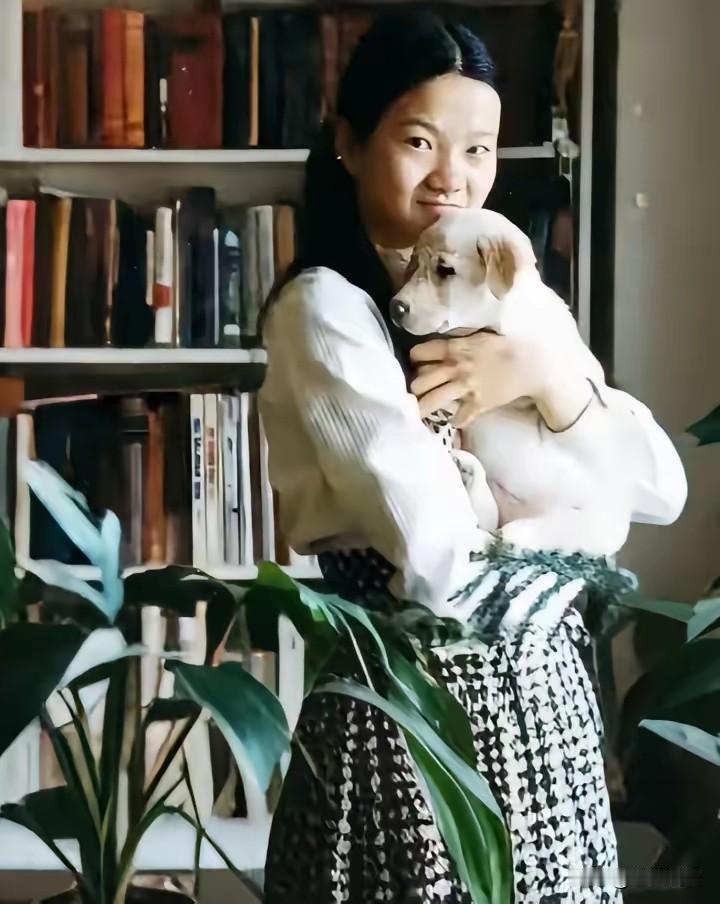 80年代，年轻时的洪晃，在家中书房抱着宠物狗时的珍贵留影，那时的她，留着一头乌黑