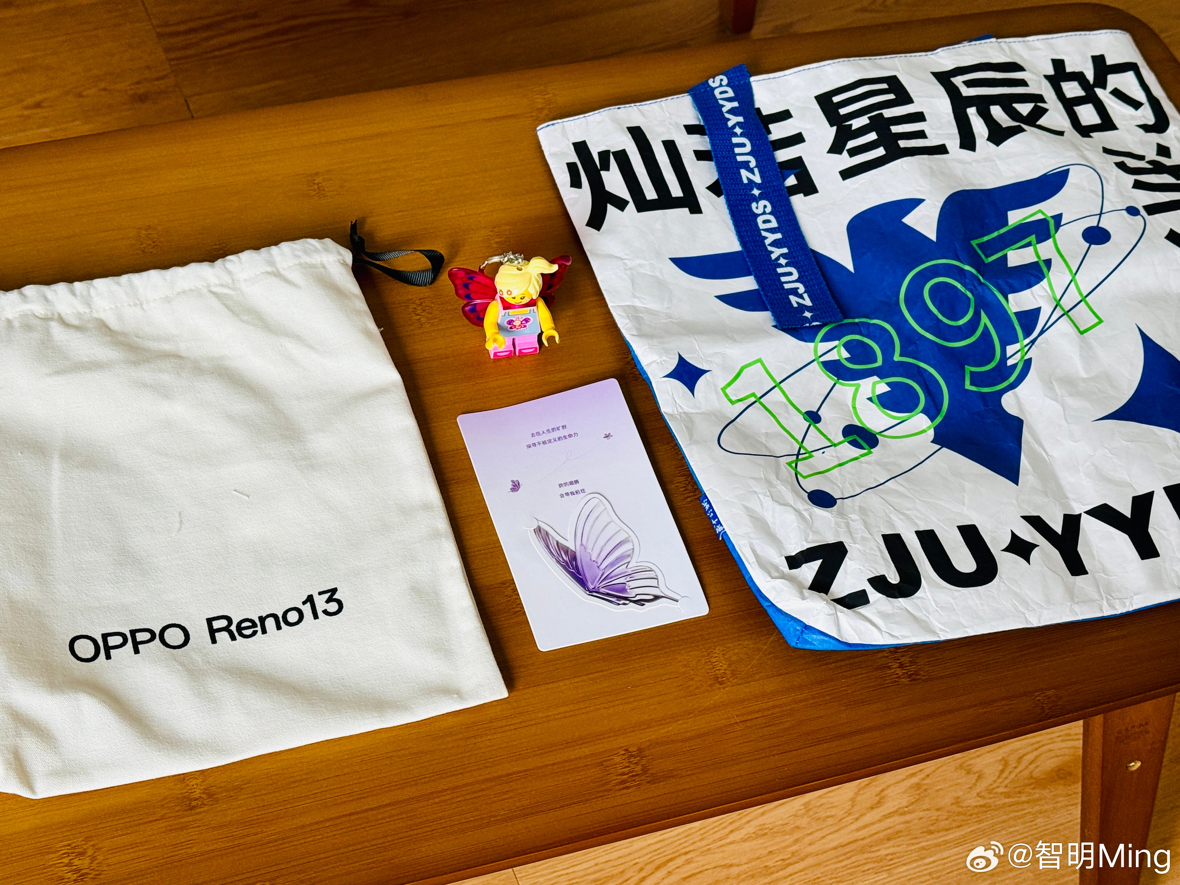 收到OPPO Reno13系列邀请函，里面有一个浙大文创单肩包和乐高蝴蝶女孩钥匙
