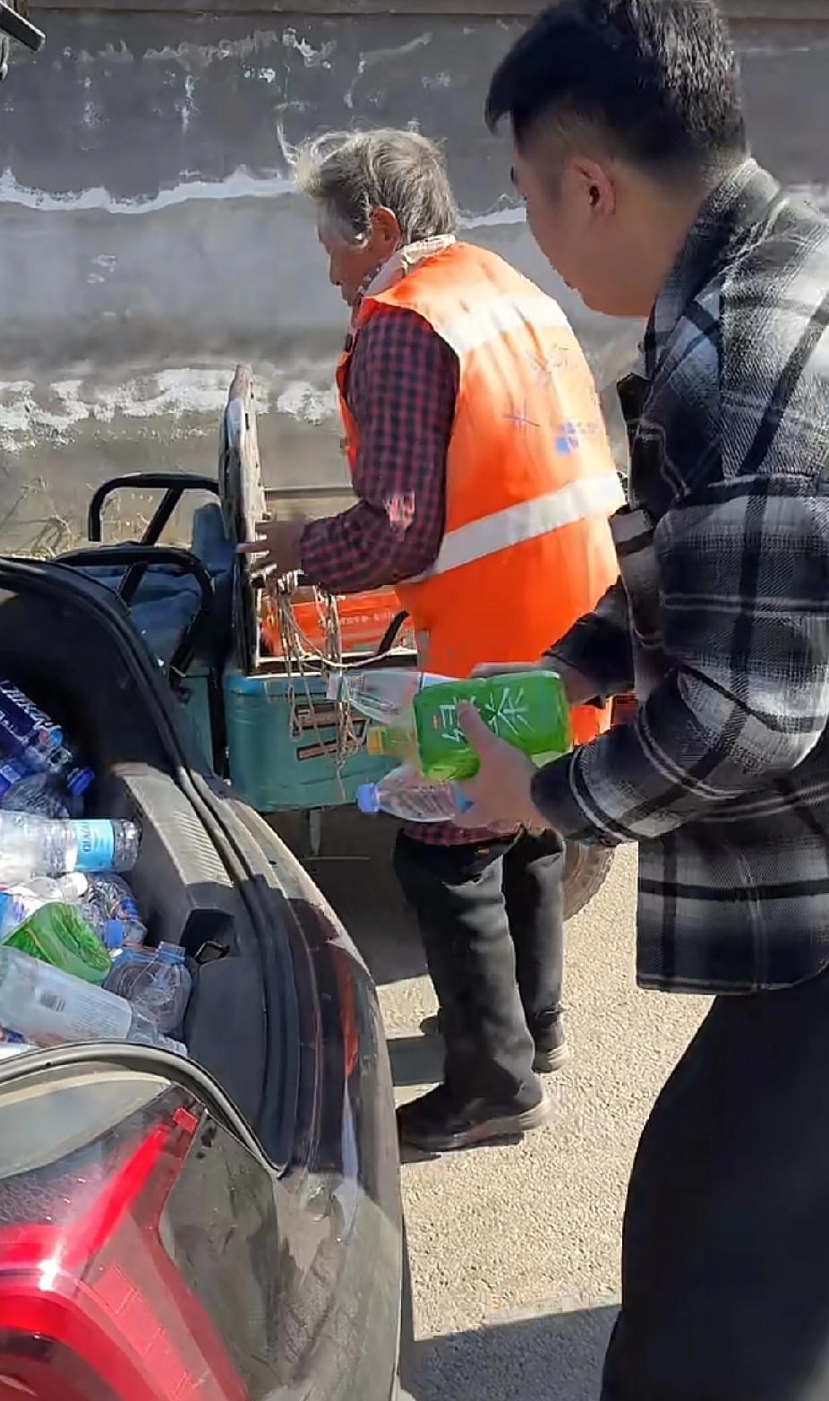 年轻男子突然拦住一位环卫老人，让环卫工老人将自己车上后备箱的垃圾拿走，接下来的画