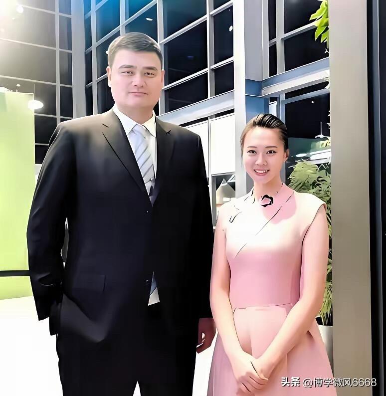 穿着黑色西装，身材高大的是篮球运动员姚明，他真的很独特，一般人跟他的合影总会被他