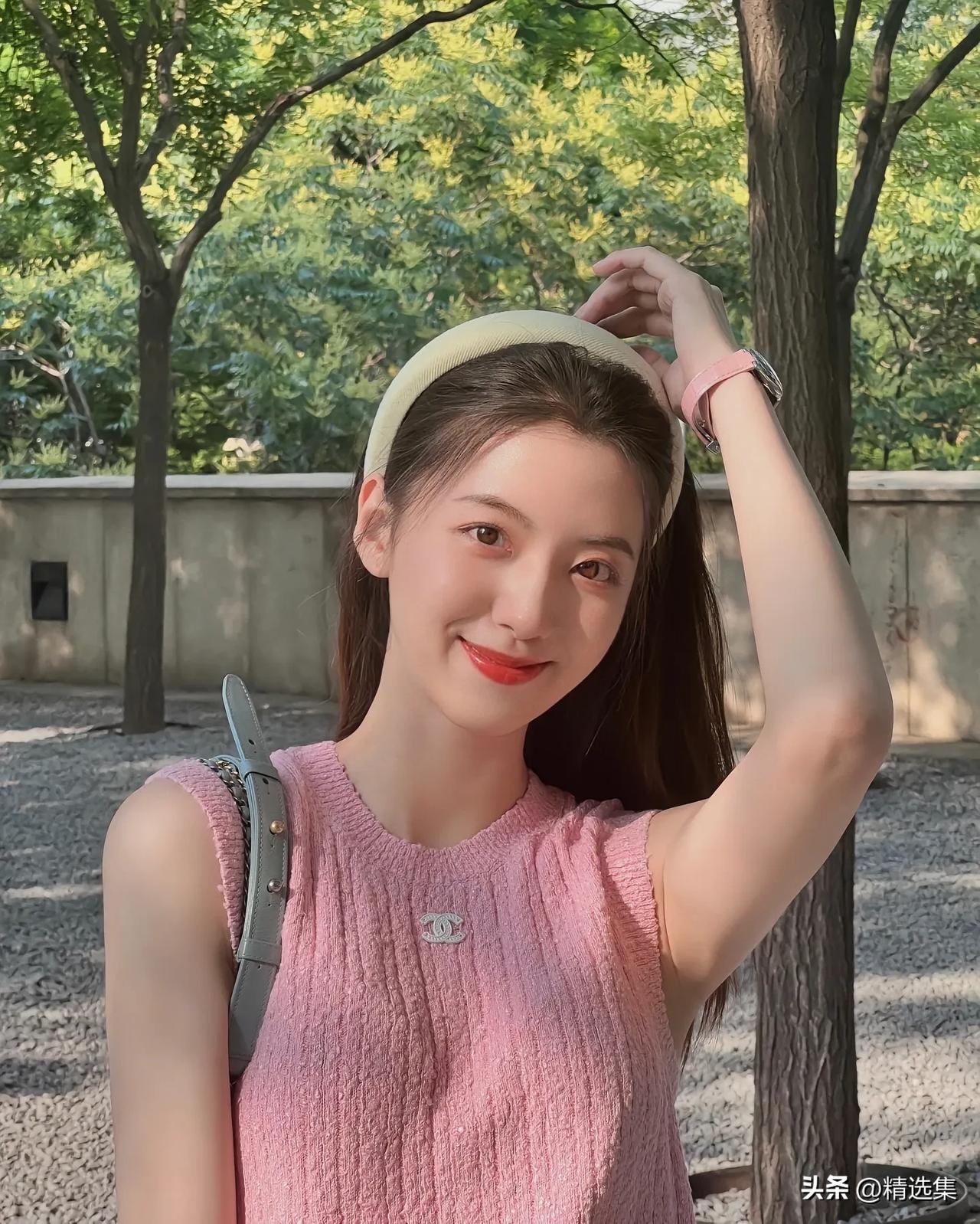 粉衣少女倚树笑，绿意盎然映芳颜。
