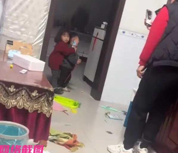 广东有家是两个孩子，当中做姐姐此刻和自己的弟弟玩闹，拿起家里的玩具做出劫持弟弟的