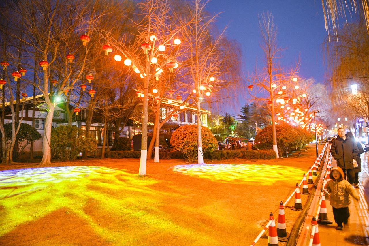 2月15日晚，大明湖南门处流光溢彩。安装在生态廊道上的数千盏红灯笼全部点亮，如一