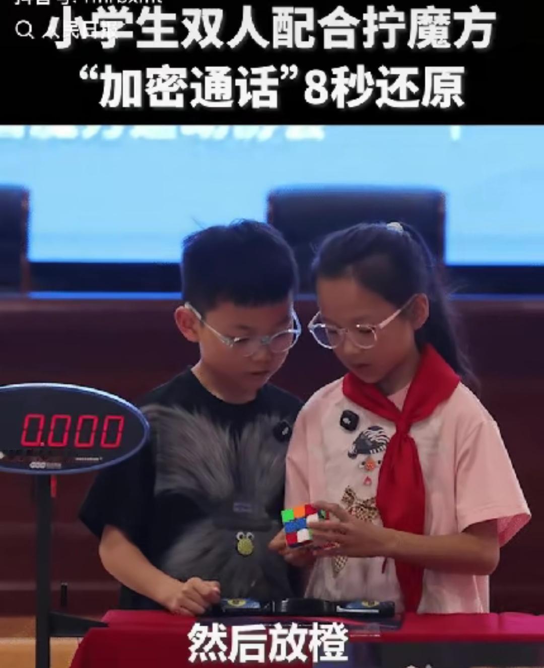 江苏海安，两名小学生参与校园魔方联赛，比赛还没开始前，女生拿起魔方，翻了翻说了一