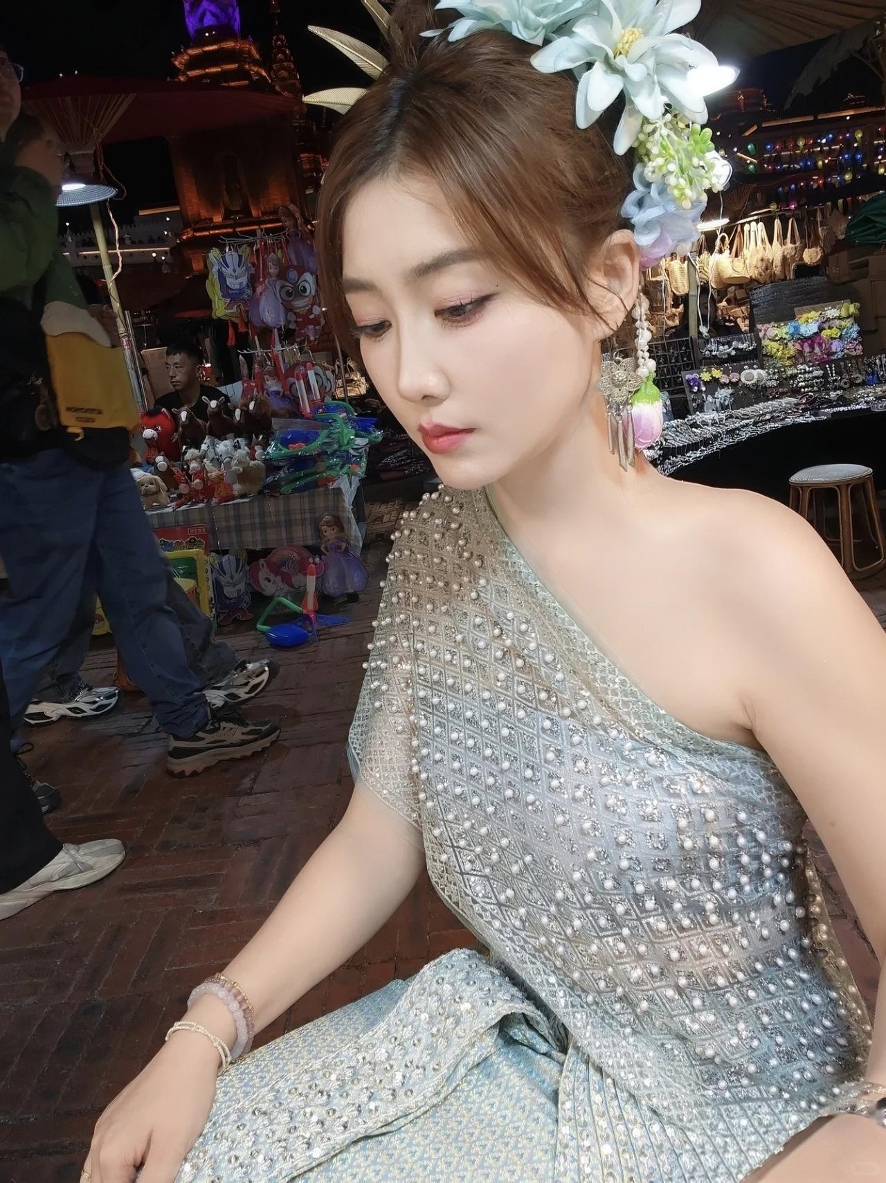 在泰国夜市解锁泰式盛装体验啦✨
浅薄荷绿的泰服缀满珍珠和碎钻，在夜市暖光里闪着温