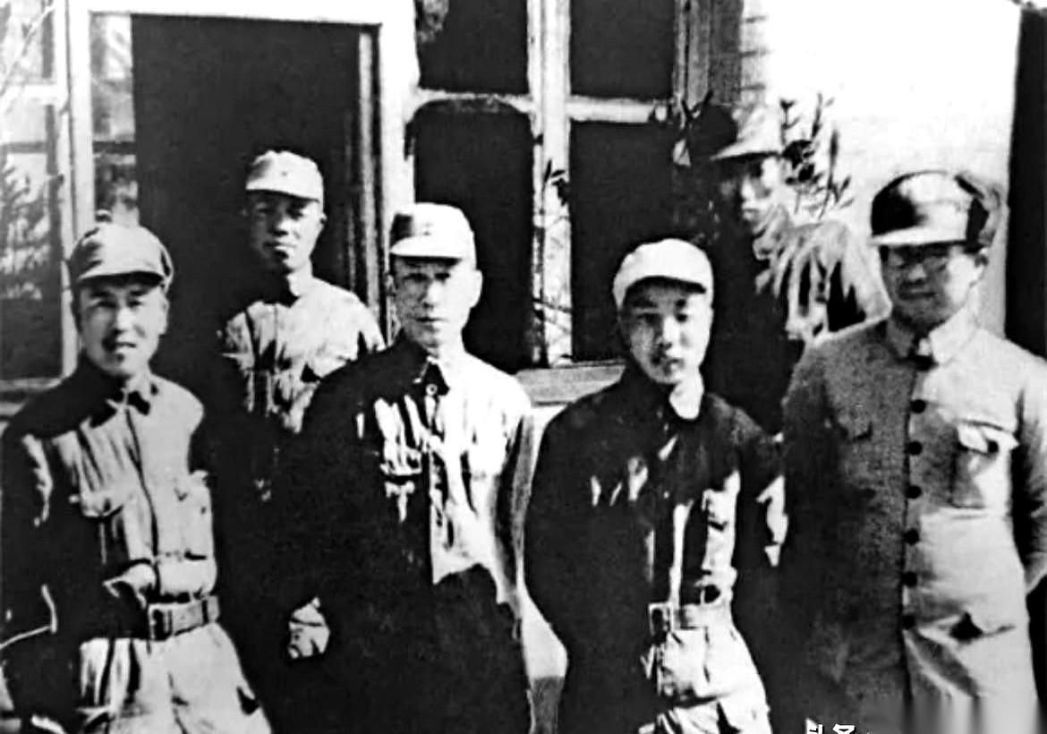1942年，山东临沭一个叫朱樊村的小院里，几个人坐在一张长凳上。
相机要拍了，但