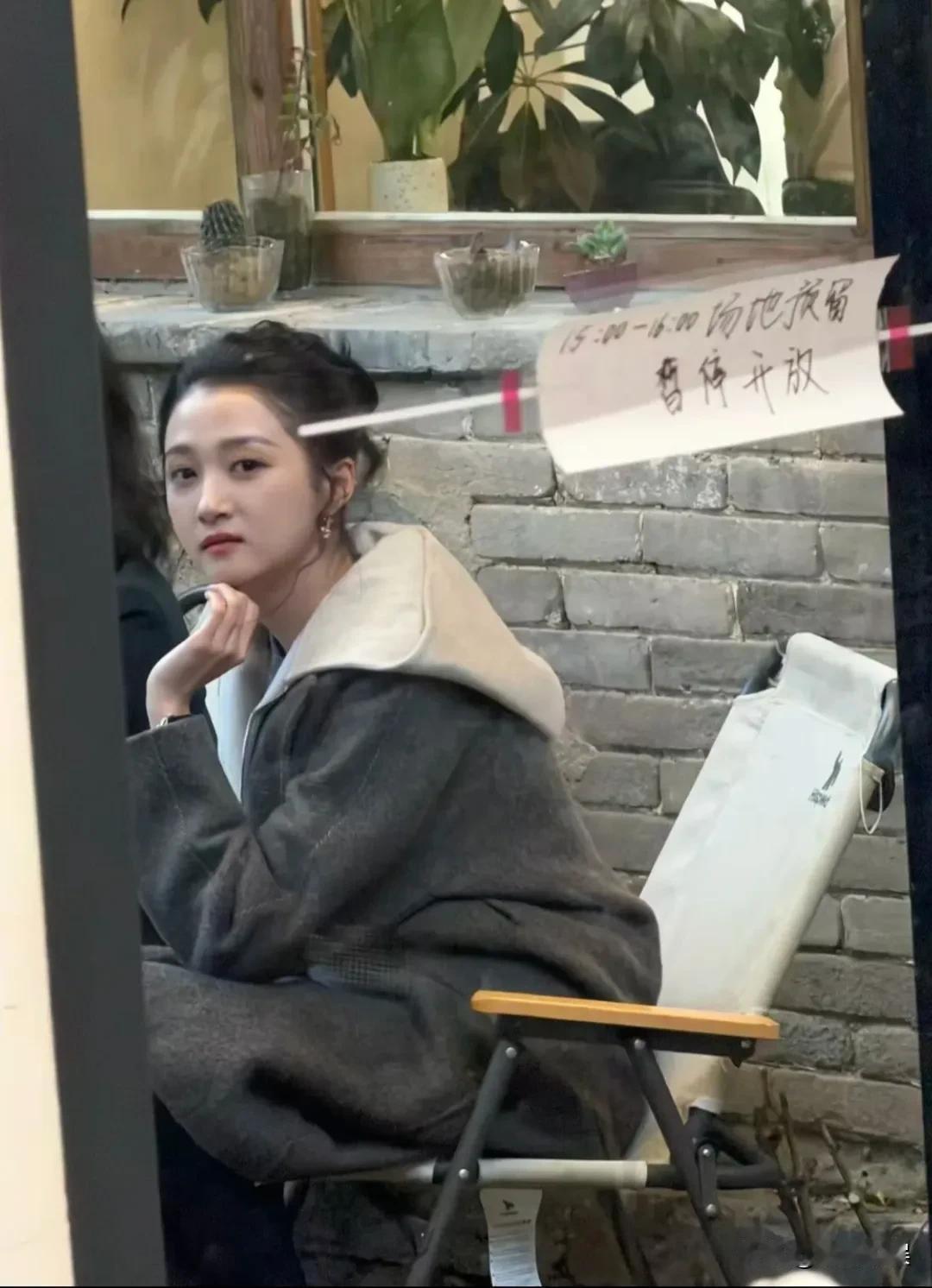 关晓彤和撒贝宁一起在北京一家咖啡馆录节目。
扎着丸子头，穿着一件灰色的长外套，化