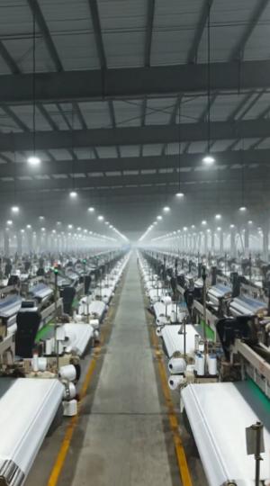 【新疆一家大型纺织厂在没有一名工人的情况下运转。】五千台织布机在人工智能和机器人