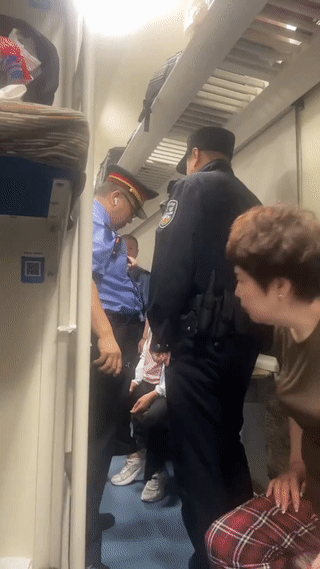 一名乘客在火车上突发疾病脸色惨白，非常难受！
列车员和乘警赶来查看乘客情况。
最