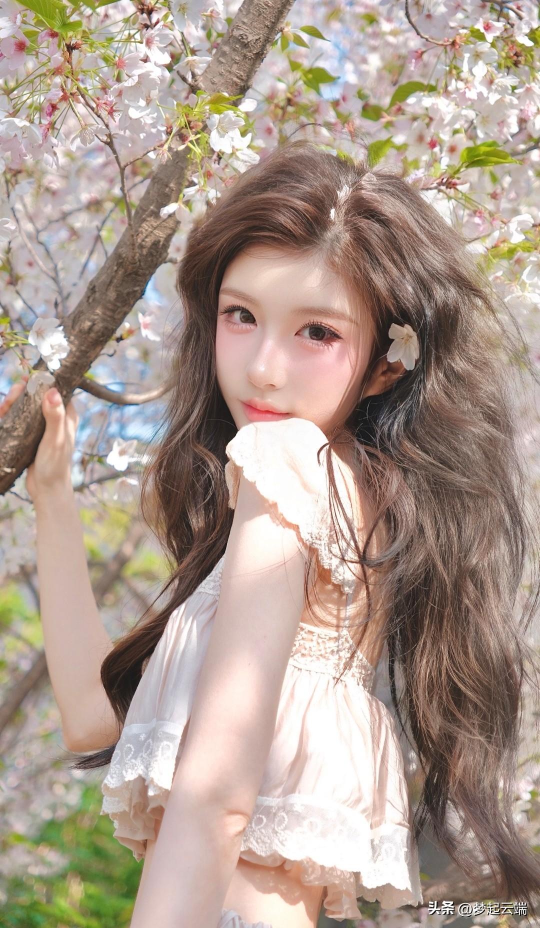 樱花树下，少女轻抚树枝，粉嫩的裙摆随风飘动，宛如童话中的仙境。🌸💕