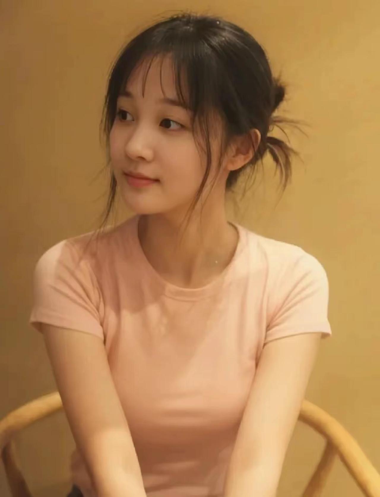 温柔甜美的少女，浅粉色T恤，自然妆容，散发着青春气息。
